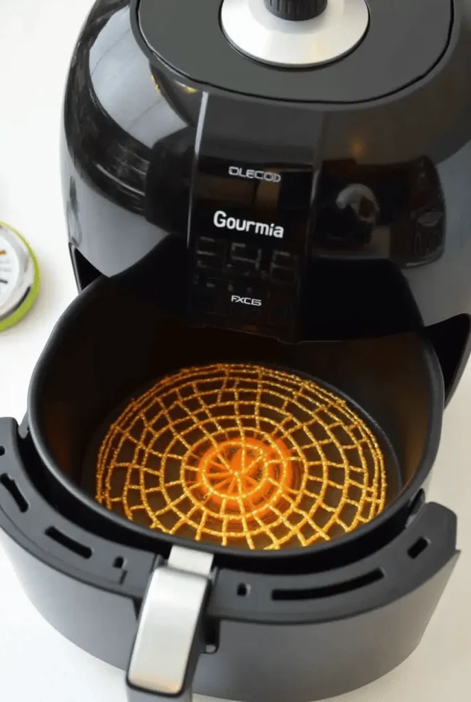 A Gourmia air fryer in preheating mode with its basket partially open showing the heated interior, demonstrating the essential preheating technique for crispy results.